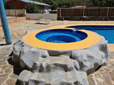 a swimming pool with a large rock around it at Hermosa Paradise in Playa Hermosa