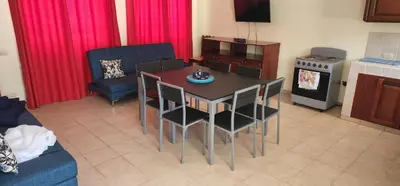 a living room with a table and chairs and a kitchen at Hermosa Paradise in Playa Hermosa
