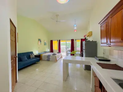 a kitchen and living room with a blue couch in a room at Hermosa Paradise in Playa Hermosa