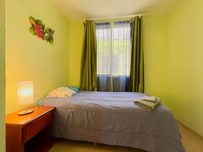 a small bedroom with a bed and a window at Hermosa Paradise in Playa Hermosa