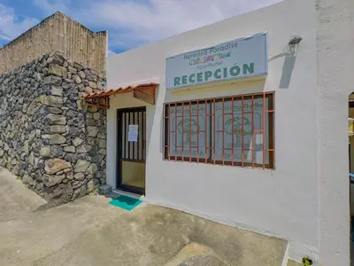 a white building with a sign that reads reception at Hermosa Paradise in Playa Hermosa