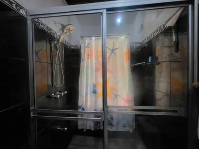 a shower stall with a shower curtain in a room at Villas Playa Palo Seco in Parrita