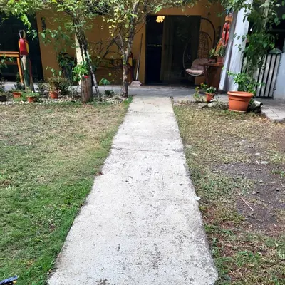a sidewalk in front of a yard with a house at Villas Playa Palo Seco in Parrita