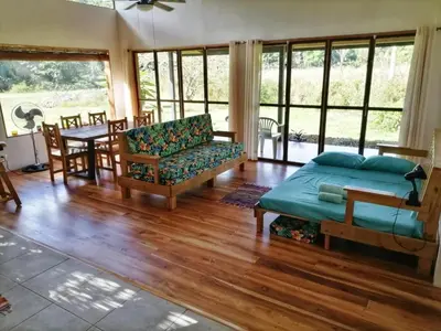 a living room with a bed and a couch and a table at Jungle Bungalow in Drake Bay in Drake