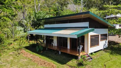 a small house with a green roof on a yard at Jungle Bungalow in Drake Bay in Drake