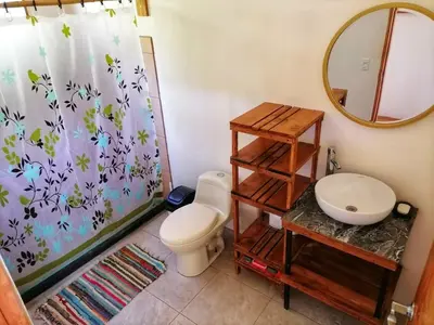a bathroom with a toilet and a shower curtain at Jungle Bungalow in Drake Bay in Drake