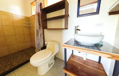 a bathroom with a toilet and a sink at Jungle Cabin in Drake Bay in Drake