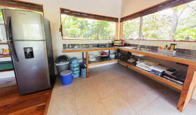 a kitchen with a stainless steel refrigerator and a window at Jungle Cabin in Drake Bay in Drake