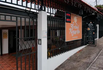 a restaurant with a sign on the side of a building at Trebol Amarillo Bed & Breakfast in Escazu