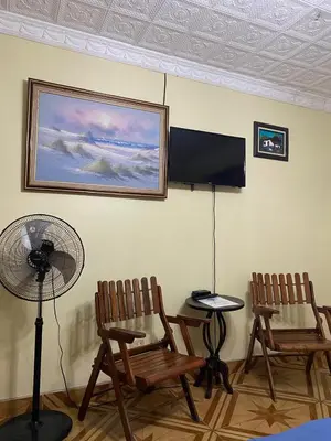 a living room with two chairs and a fan at Alexander b&b in Alajuela City