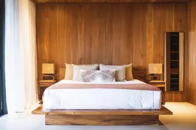 a bedroom with a large bed with wooden walls at Aguamadera Ocean View Villas in Santa Teresa Beach