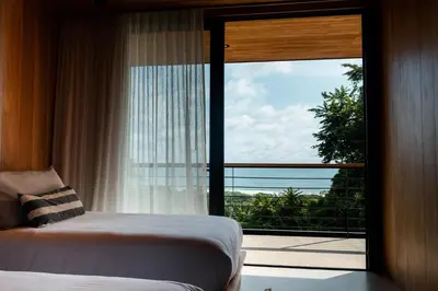 a bedroom with a large window with a view of the ocean at Aguamadera Ocean View Villas in Santa Teresa Beach