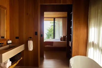 a bathroom with a bedroom with a bed and a window at Aguamadera Ocean View Villas in Santa Teresa Beach
