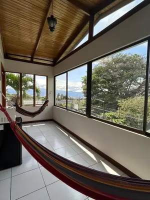 a room with a hammock in a room with windows at Casa Familiar la Tortuga in Heredia