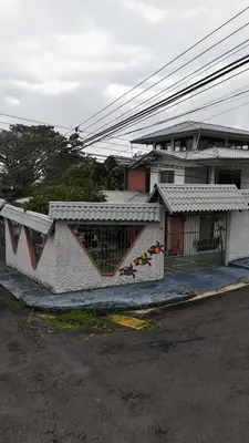 a building with graffiti on it next to a street at Casa Familiar la Tortuga in Heredia