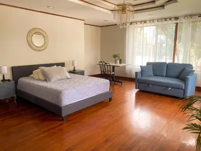 a bedroom with a bed and a blue couch at Casa Familiar la Tortuga in Heredia