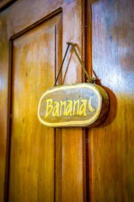 a sign on a wooden door that says banquet at Pura Vida Mini Hostel Santa Teresa in Santa Teresa Beach