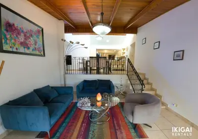 a living room with a blue couch and two chairs at Casa Rinu in San José