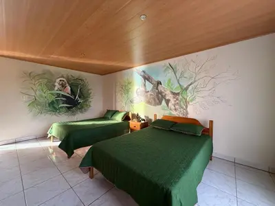 a room with two beds and a painting on the wall at La Tigra Mountain House in San Gerardo