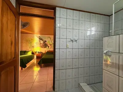 a room with a room with a bed and a refrigerator at La Tigra Mountain House in San Gerardo