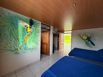 a bedroom with a peacock painting on the wall at La Tigra Mountain House in San Gerardo