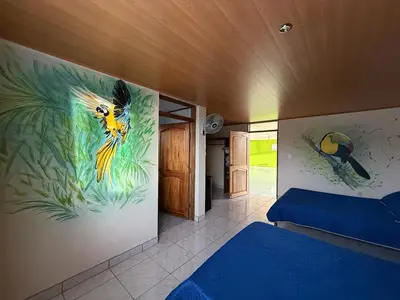 a bedroom with a painting of a bird on the wall at La Tigra Mountain House in San Gerardo