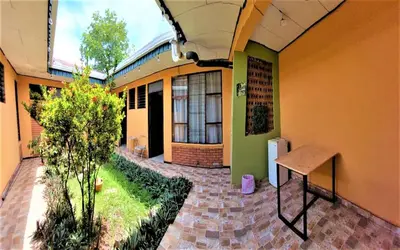 a building with a bench in the middle of a courtyard at Hospedaje Doña koko in Puerto Limón