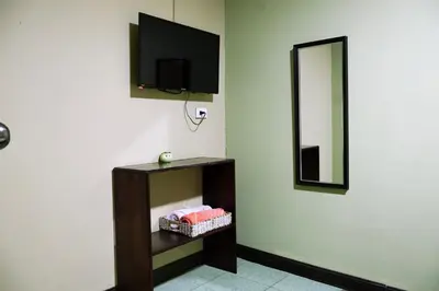a room with a mirror and a tv on a wall at Hospedaje Doña koko in Puerto Limón