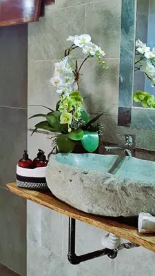 a bathroom sink with a vase of flowers on a counter at Canal Grande Lodge in Piedades