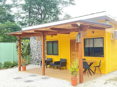 a yellow house with a table and chairs at Casa CAXTUS in Brasilito