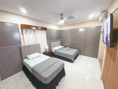 a bedroom with two beds and a flat screen tv at Casa CAXTUS in Brasilito