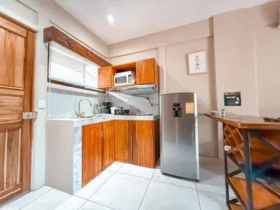 a kitchen with wooden cabinets and a stainless steel refrigerator at Casa CAXTUS in Brasilito