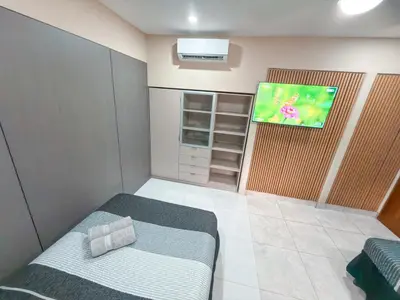 a small room with a bed and a flat screen tv at Casa CAXTUS in Brasilito