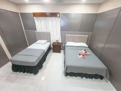 a room with two beds and a teddy bear on top of it at Casa CAXTUS in Brasilito