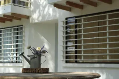 a vase with flowers on a table in a room at Casa Buda Liberia Cerca del Aeropuerto in Liberia