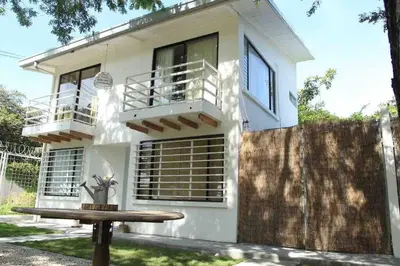 a white house with a table in front of it at Casa Buda Liberia Cerca del Aeropuerto in Liberia