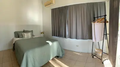 a bedroom with a bed and a large window at Casa Buda Liberia Cerca del Aeropuerto in Liberia