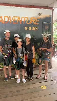 a group of people standing in front of a sign at Palm Beach Inn in Playa Grande
