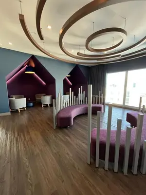 a room with purple furniture and a large ceiling at Bambu-Rivera Club Residences in San José