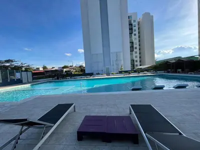 a swimming pool with a purple bench next to a building at Bambu-Rivera Club Residences in San José