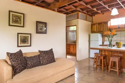 a living room with a couch and a kitchen at Coffee Garden Ranch Costa Rica in Concepción
