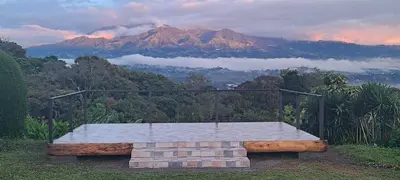 a bench on a hill with a view of a mountain at Coffee Garden Ranch Costa Rica in Concepción