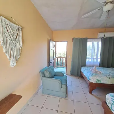 a living room with a chair and a bed at Georgi, Junquillal in Playa Junquillal