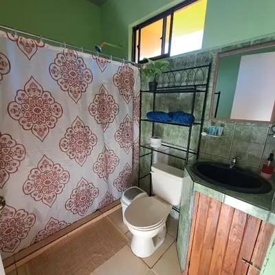 a bathroom with a toilet and a sink and a mirror at Georgi, Junquillal in Playa Junquillal