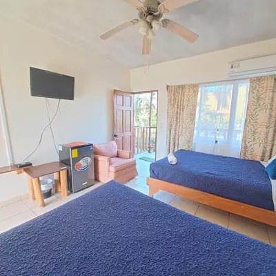 a bedroom with two beds and a tv in it at Georgi, Junquillal in Playa Junquillal
