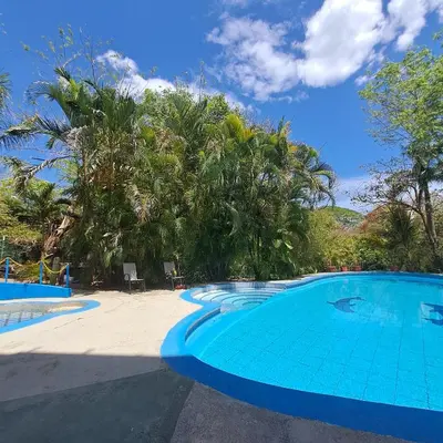 a large swimming pool in a resort with trees at Georgi, Junquillal in Playa Junquillal