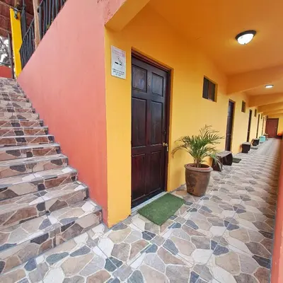 a building with a door and a potted plant on the sidewalk at Georgi, Junquillal in Playa Junquillal