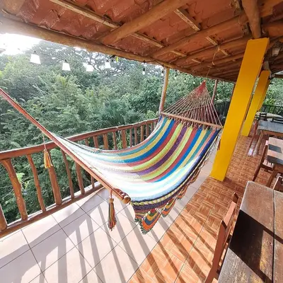 a hammock hanging on a balcony of a house at Georgi, Junquillal in Playa Junquillal