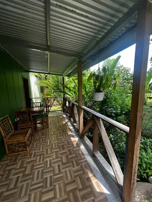 a porch of a house with a table and chairs at Ballena Oasis Homes & Glamping in Uvita