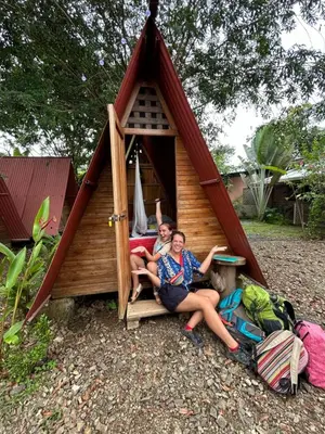a group of three people sitting in front of a play house at Ballena Oasis Homes & Glamping in Uvita